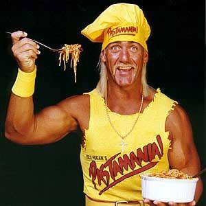 Hulk Hogan in a Chef's hat holding a forkful of pasta and smiling like an idiot.